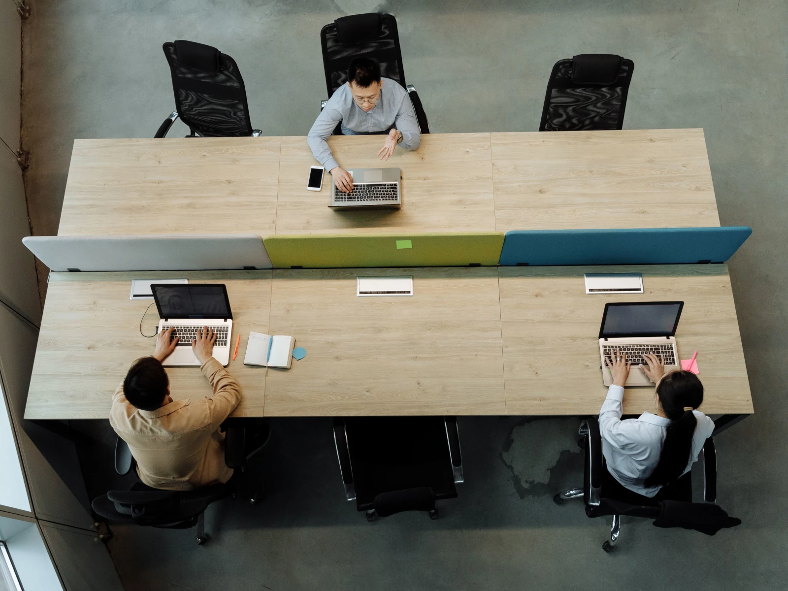 a group of people sitting at a table with computers